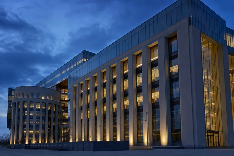 Editorial photograph of a modern Ontario government office building facade at dusk with clean architectural lines and blue-hour lighting